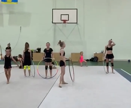 Гимнастки клуба ДЕРЖАВА тренируются с обручем на ковре на летних сборах
